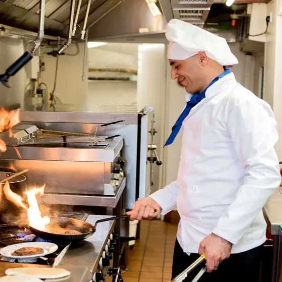 Hudson Estates Chef Created Meals, chef frying a dish.