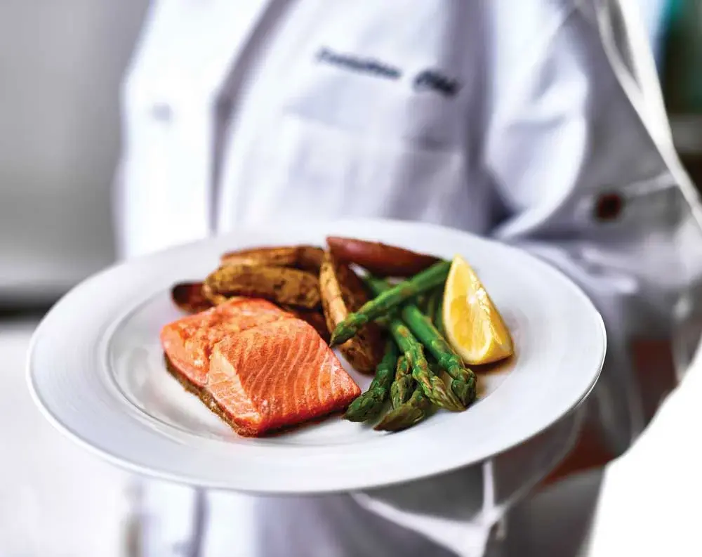 Hudson Estates Chef Created Meals, chef delivering a finished dish.