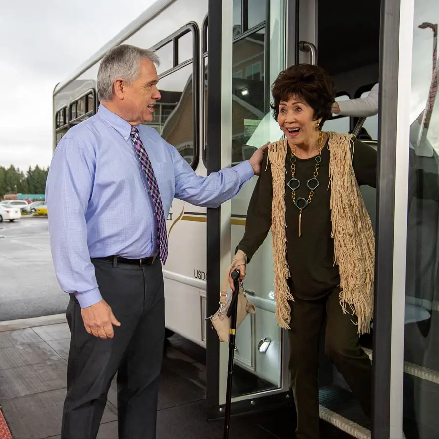 Hudson Estates man helping lady off bus
